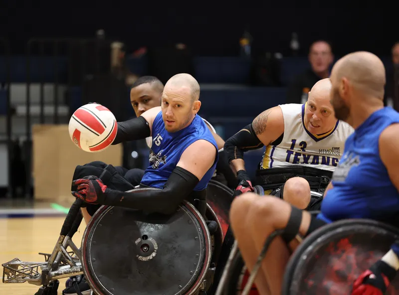 Three players collide at close quarters as the ball carrier shields the ball