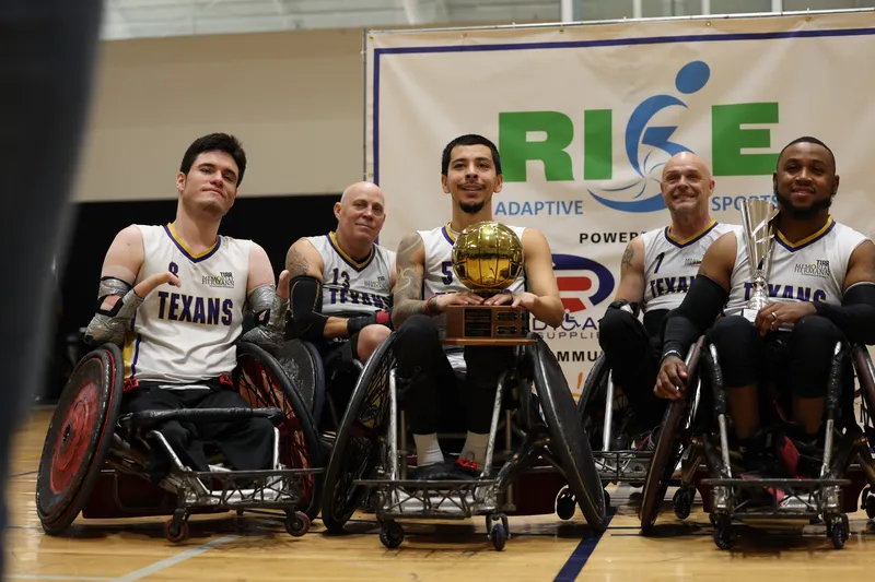 Players pose with the golden-ball championship trophy in front of the RISE banner